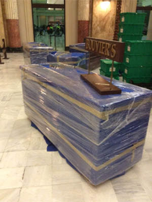 Office furniture and bins sitting inside an empty retail store space
